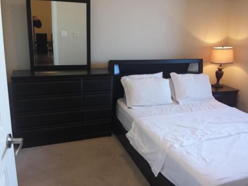 um quarto com uma cama com um espelho e uma cómoda em BEST LOCATION/SPECTACULAR VIEW 2 BEDROOMS FURNISHED CONDO S/L RENT em Mississauga