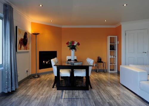 a living room with a table with a vase of flowers at Sea Star Lodge in Gansbaai
