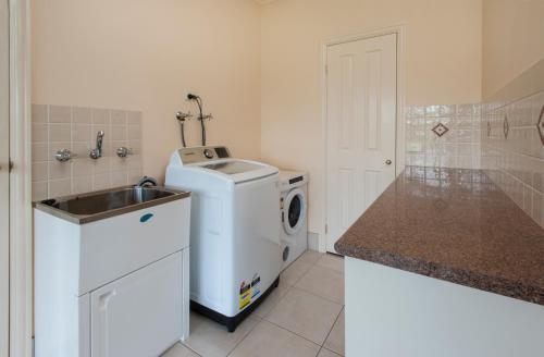 a small kitchen with a washing machine and a sink at Emerald Cottage in Emerald