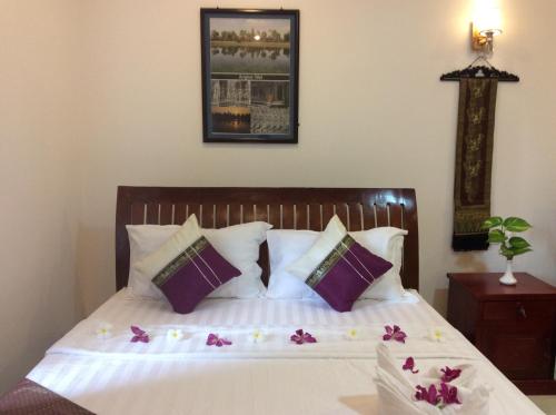 a bedroom with a bed with purple and white pillows at Davyta House in Siem Reap