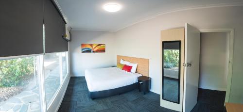 a small room with a bed and a balcony at Links Hotel in Adelaide