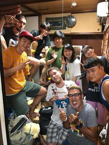 筑紫野市にあるノリシコオートゲストハウスの部屋の中で写真を撮る人々のグループ