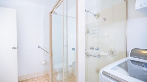 a bathroom with a shower and a sink and a toilet at Driftwood Beachfront @ Vincentia in Vincentia