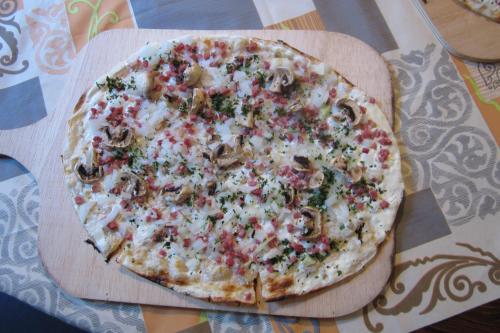 a pizza sitting on top of a wooden cutting board at Hotel-Café-Burg Stahleck in Bacharach