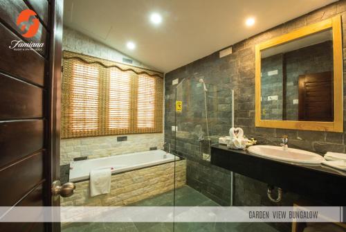 a bathroom with a bath tub and a sink at Famiana Green Villa in Phu Quoc