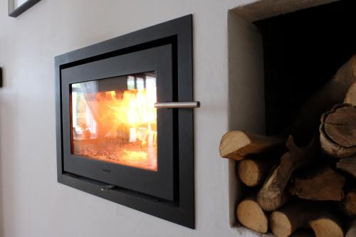 a television with a fire in a wall at Vine Guesthouse in Stellenbosch