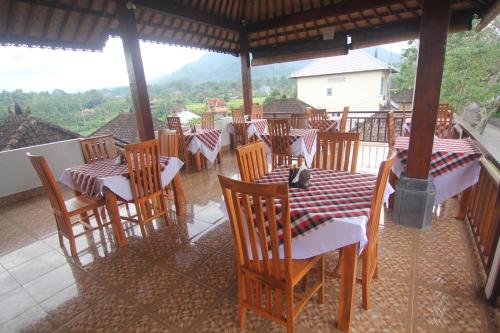 a restaurant with tables and chairs on a balcony at Giri Carik in Sidemen