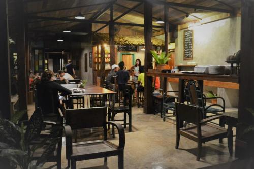 a group of people sitting at tables in a restaurant at Le Cocotier in Ban Cho Lae