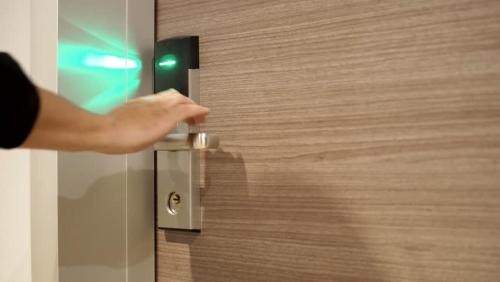 a person opening a door with their hand on it at Kenz Residency in Cochin