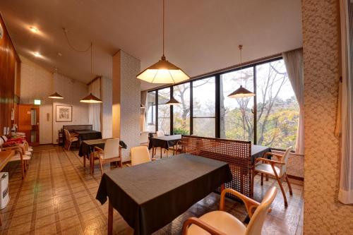 a restaurant with tables and chairs and a large window at Mizu no Kaori in Hakone