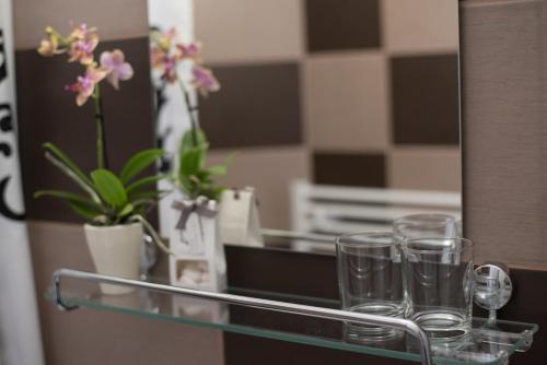 a group of glasses sitting on a counter with a mirror at Nefelejcs Vendégház in Tóalmás