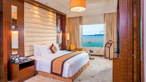 a hotel room with a bed and a large window at Royal Halong Hotel in Ha Long