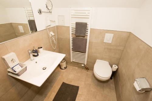 uma casa de banho com um WC branco e um lavatório. em Hotel Gut Grossrotter Hof (ehem. Hotel Schmitte) em Colônia