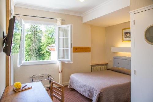 Ένα ή περισσότερα κρεβάτια σε δωμάτιο στο Hostellerie de La Roseraie