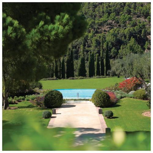 a garden with a pathway and a swimming pool at Château Saint-Martin & Spa, Oetker Hotels in Vence