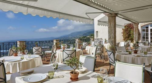 a restaurant with white tables and chairs with a view at Château Saint-Martin & Spa, Oetker Hotels in Vence