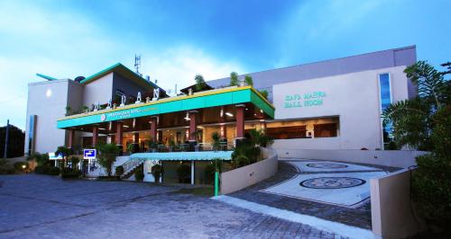 a building with people sitting on top of it at Grand Madani Hotel in Mataram