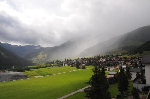 a small town in a green valley with mountains at Casa La Foppa 28 in Sedrun