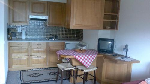 a small kitchen with a table and a small tv at Casa La Foppa 28 in Sedrun