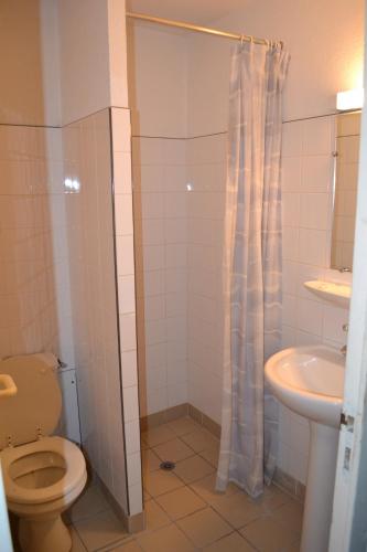 a bathroom with a toilet and a sink at Auberge Les Sibourgs in Bourdeaux