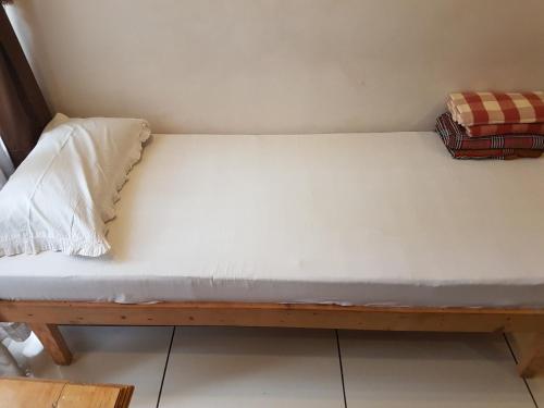a bed in a room with a white mattress at Jojies Homestay Fortkochi in Cochin