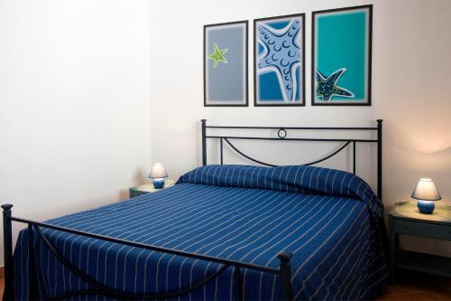 a bedroom with a bed with a blue comforter at Residence Scirocco e Tramontana in Favignana