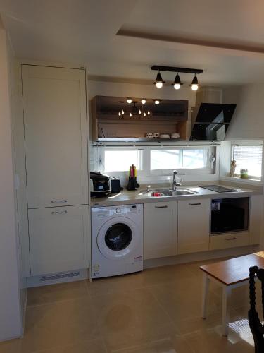 a kitchen with a sink and a washing machine at HANI Haus in Jeju