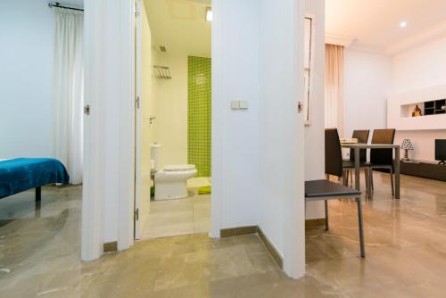 a room with a toilet and a dining room at Apartamento Tebaida in Granada