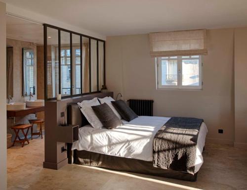 a bedroom with a large bed and a bathroom at Les Berceaux de la Cathedrale in Reims