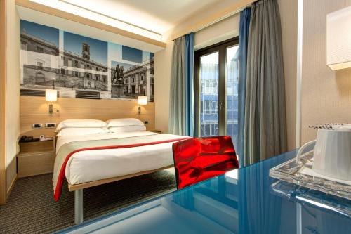 a hotel room with a bed and a glass table at iQ Hotel Roma in Rome