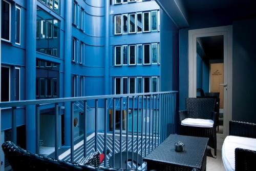 a balcony with a blue wall and a table and chairs at iQ Hotel Roma in Rome