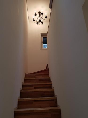 a stairway with a chandelier and wooden stairs at HANI Haus in Jeju