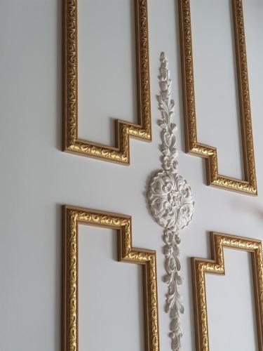 a pair of gold frames hanging on a wall at HANI Haus in Jeju