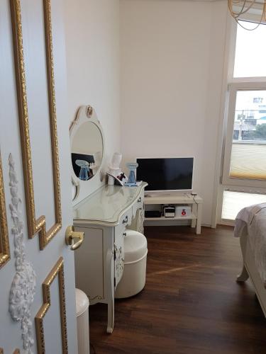 a white bathroom with a mirror and a tv at HANI Haus in Jeju