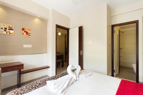 a bedroom with a bed with a heart shaped towel at D Homz Suites in Cochin