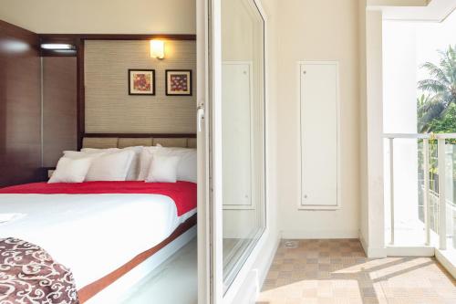 a bedroom with a bed with a red blanket at D Homz Suites in Cochin