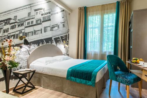 Habitación de hotel con cama, escritorio y silla en FH55 Grand Hotel Mediterraneo, en Florencia