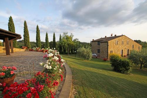 a garden with flowers and a building in the background at Borgo Di Collelungo in Montaione