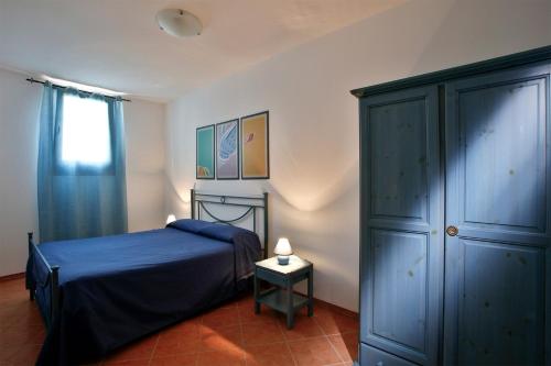 a bedroom with a blue bed and a cabinet at Residence Scirocco e Tramontana in Favignana