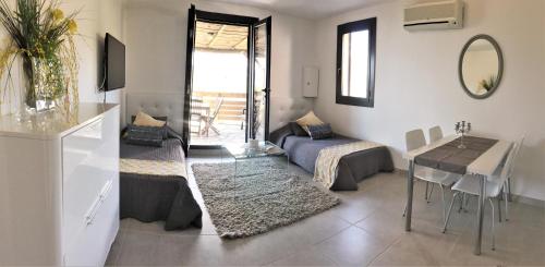 - un salon avec un canapé, une table et une salle à manger dans l'établissement Residence Bellavista à Santa Giulia, proche de la plage et vue mer, à Porto-Vecchio