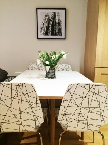 a dining room table with two chairs and a vase of flowers at Russet Quarter, Parking subject to availability in York