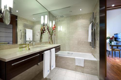 a bathroom with a tub and a sink at Eurostars Berlin in Berlin