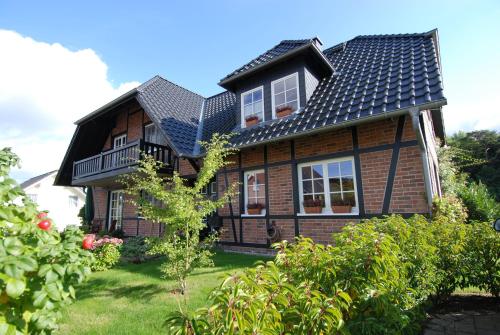 a house with a black roof on a yard at Haus Gode Tied - Apt. 01 in Ostseebad Sellin