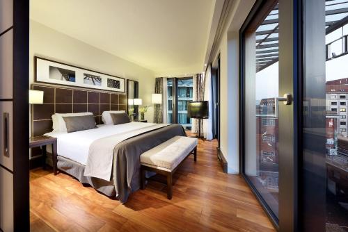 a bedroom with a bed and a large window at Eurostars Berlin in Berlin