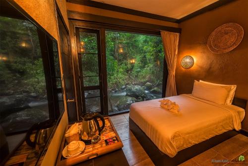 a bedroom with a bed and a large window at Namkat Yorla Pa Resort in Ban Kat