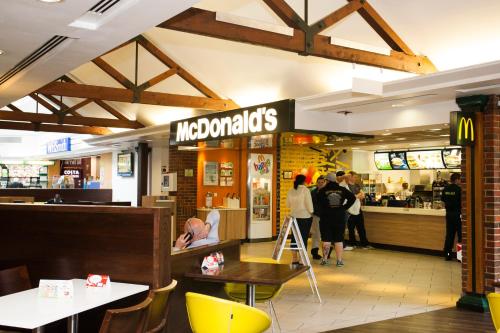 a mcdonalds restaurant with people standing around a counter at Days Inn by Wyndham Sevenoaks Clacket Lane in Westerham