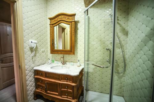 a bathroom with a sink, mirror and bath tub at Hotel Wine Palace in Tbilisi City