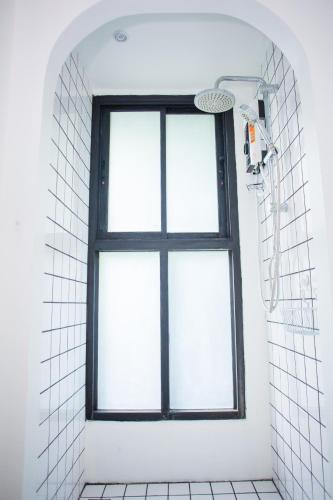 a shower with a window in a white bathroom at Trat 101 Hotel - SHA Certified in Trat