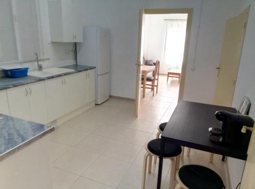 a kitchen with white cabinets and a black counter top at Casa Carmen Barcelona in El Prat de Llobregat