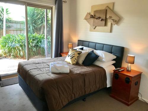 a bedroom with a large bed with a large window at Short Stays Gippsland (Newborough) in Moe